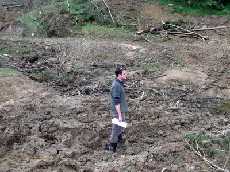 Northland Regional Council Monitoring Officer Tim Senington stands in a Northland stream so blocked with forestry slash and sediment it is barely recognisable as a water body.